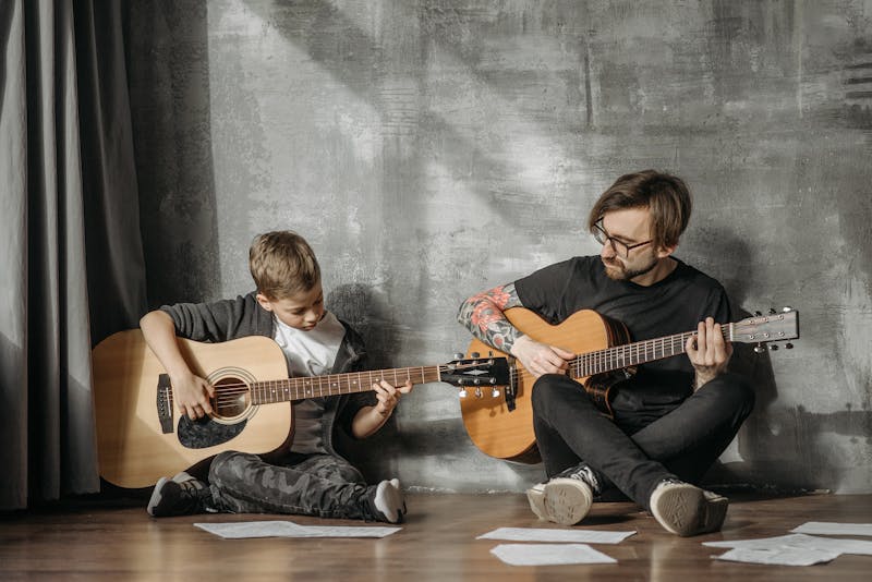Vater und Sohn spielen gemeinsam Gitarre